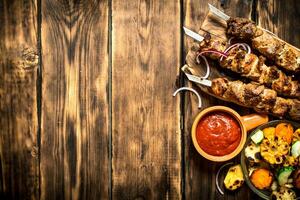 Kebab with tomato sauce and roasted vegetables. photo
