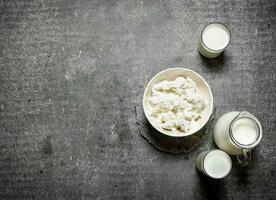 The cottage cheese in a bowl and milk. photo