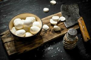 Fresh mozzarella with a hatchet for cutting. photo