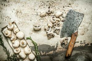 Sliced mushrooms with spices and a large hatchet. photo
