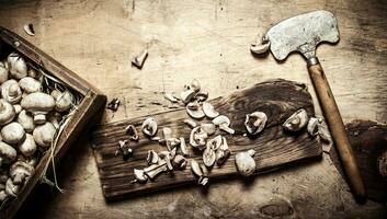 Cutting fresh mushrooms old hatchet. photo