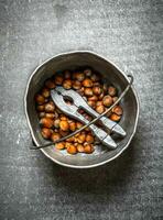 Hazelnuts with Nutcracker in the old pot. photo