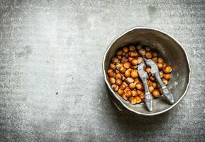 Hazelnuts with Nutcracker in the old pot. photo