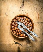 Nuts with Nutcracker in a bowl . photo