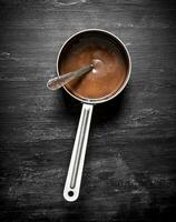 Fresco chocolate mantequilla en un pequeño cacerola. foto