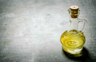 Olive oil in a jug. On stone background. photo