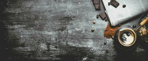 Brewed coffee pot with fresh newspaper and bitter chocolate. photo