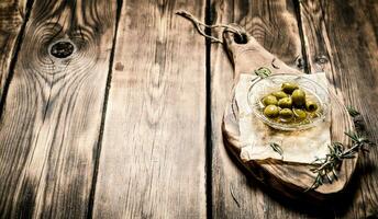 Olives in oil and rosemary branches on the Board. photo