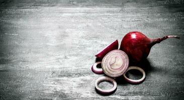 Fresh red onions. On black rustic background. photo