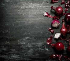 Red onion . On black rustic background. photo