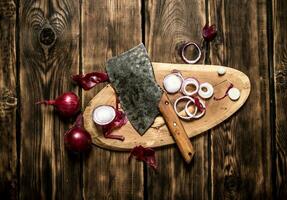 Sliced red onion and an old hatchet. photo