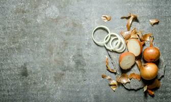 Fresh onions from the husk. On stone background. photo