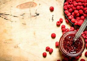 Sweet raspberry jam in jar with spoon. photo