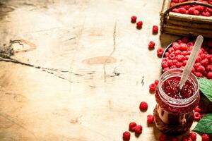 Sweet raspberry jam in jar with spoon. photo