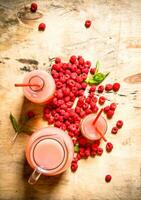 Raspberry juice in the pitcher and glasses. photo