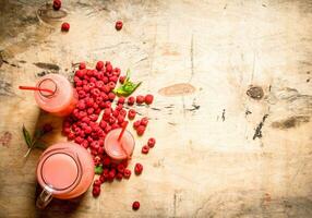 Raspberry juice in the pitcher and glasses. photo