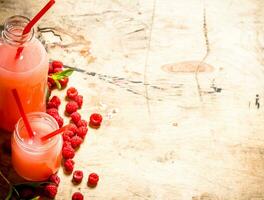 Raspberry juice in the pitcher and glasses. photo