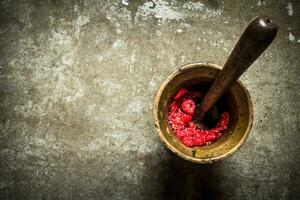 Wild raspberries in old mortar with pestle. photo