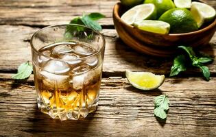 glass of rum with ice , lime and mint. photo