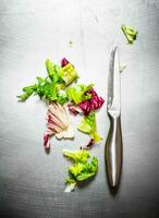 Fresh greens with a knife. photo