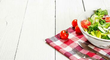 Salad of tomatoes and cucumbers with greens . photo