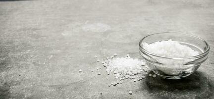 Salt in the Cup. On stone background. photo