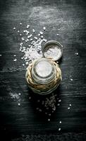 Coarse salt in saltcellar. On black rustic background. photo