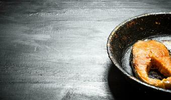 piece of grilled salmon in an old pan. photo