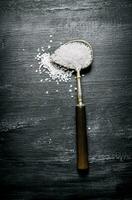 Coarse salt in a large old spoon. photo