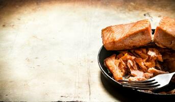 Fried trout at the plate with a fork. photo