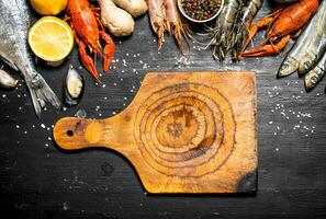 Cutting Board with a variety of shrimp, fish and shellfish. photo