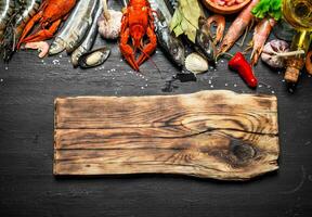 Cutting Board with a variety of shrimp, fish and shellfish. photo