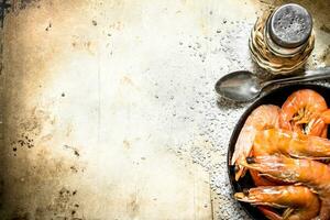 Frying pan with shrimp and salt. photo