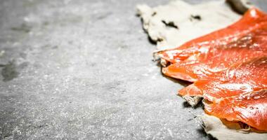 Thin slices of salmon on the old fabric. photo