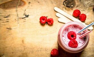 Berry smoothie raspberry with wooden sticks. photo