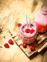 Berry smoothie raspberry with wooden sticks. photo