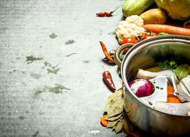 Cooking chicken soup with vegetables in a large pot. photo