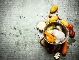Chicken soup in an old pot with vegetables. photo