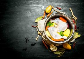 Not boiled chicken soup with fresh vegetables and spices. photo