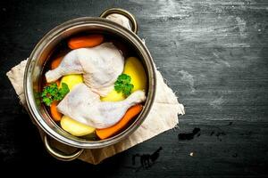 Not boiled chicken soup with fresh vegetables and spices. photo