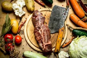 Beef with a meat axe and ingredients for soup. photo