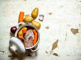 The pot of soup from meat and vegetables. photo