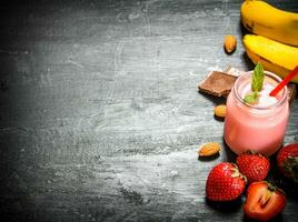 Strawberry smoothie with berries, chocolate, nuts and bananas. photo