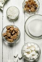 Different types of brown and white sugar in the cups. photo