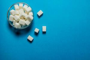 Refined sugar in the Cup. On blue table. photo