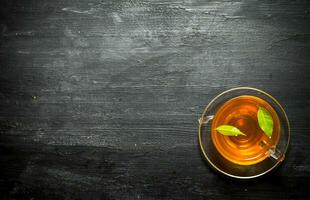 Cup of tea with green leaves. photo