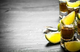 Tequila with salt and lime slices. photo