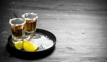 Tequila with salt and lime slices. photo