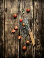 Old hatchet, and red tomatoes. photo