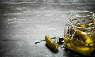 Pickled gherkins in a jar. photo